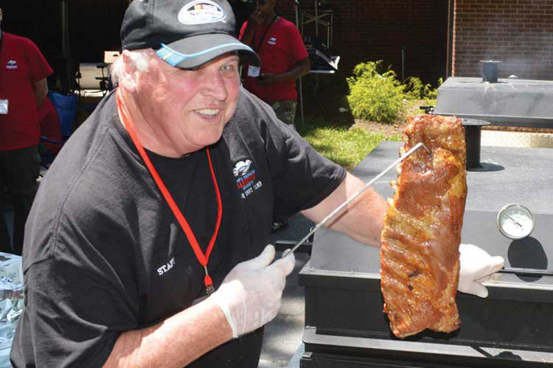 A man holding up a rack of ribs