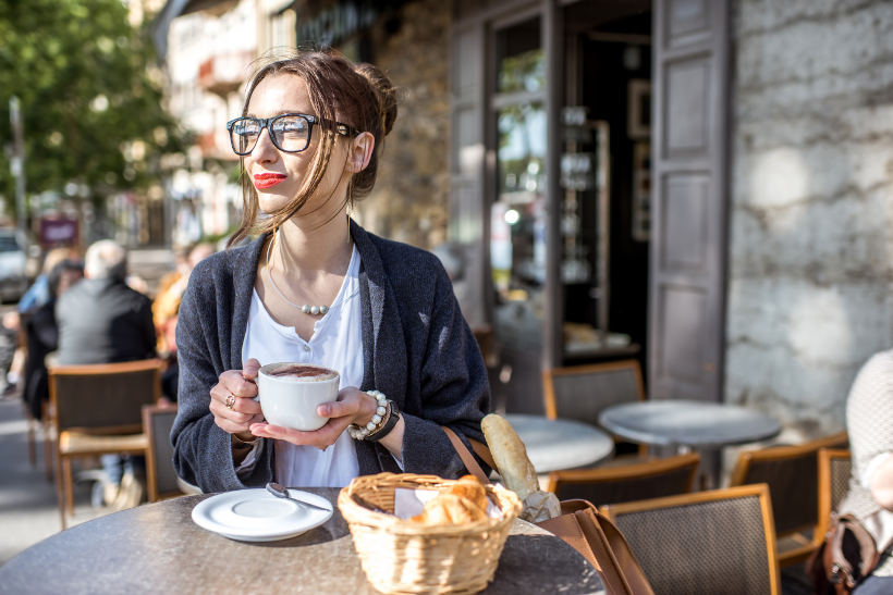 Travel Associates woman drinking coffee outside Lyon cafe