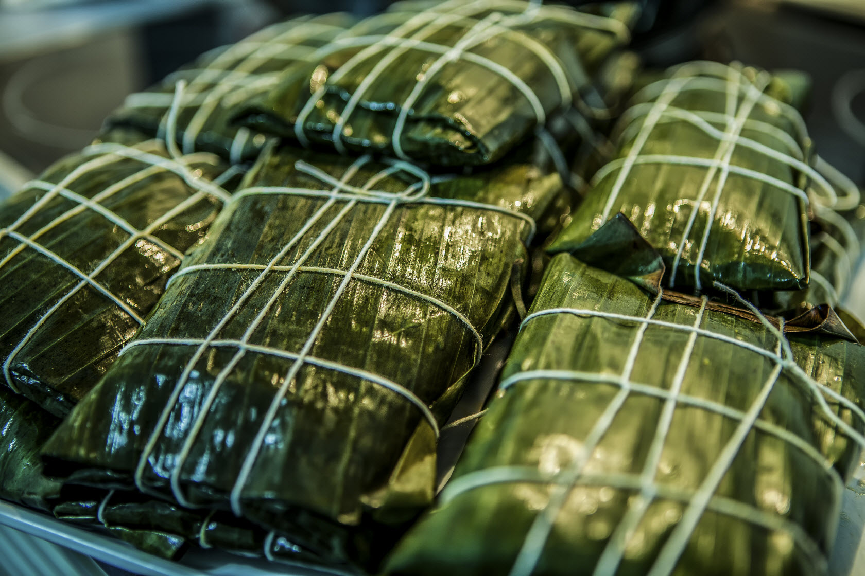 This image:  Ecuadorians wrap tamales wrapped in banana leaves, rather than corn leaves elsewhere in South America. 