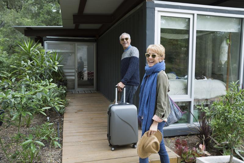 Couple arrive at vacation home with suitcases