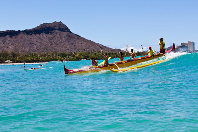 A group riding a wave in a canoe